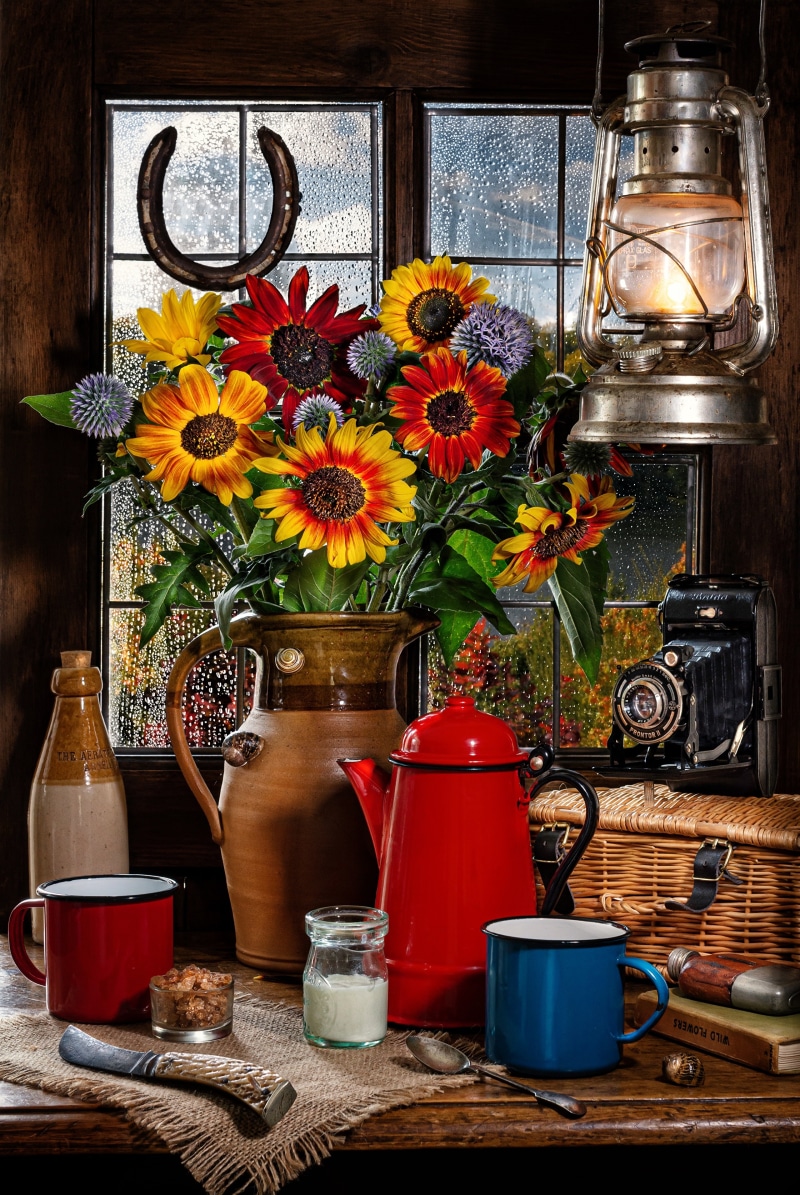 Still life with sunflowers, kerosene lamp, and camera