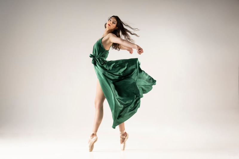 Anne-Laure in a green dress performing ballet
