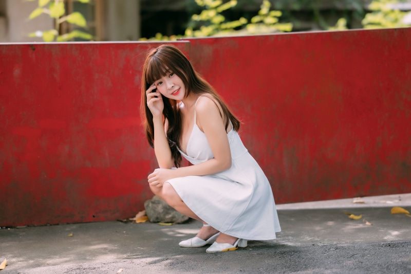 Asian woman in white dress posing