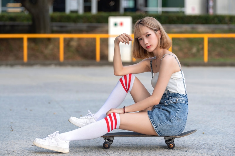Asian girl with knee-high socks on a skateboard