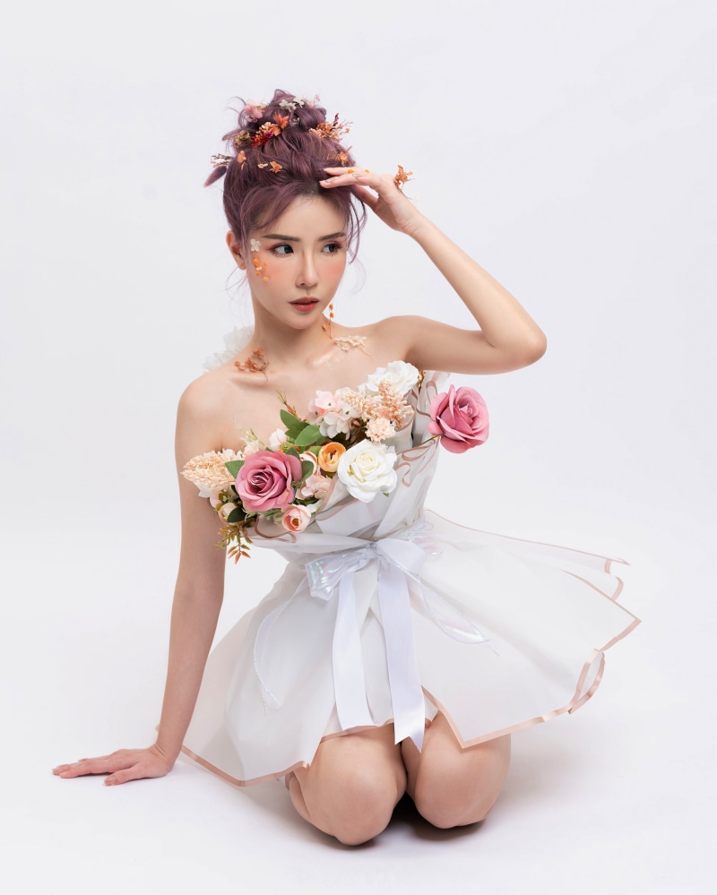 Woman in floral dress posing on gray background