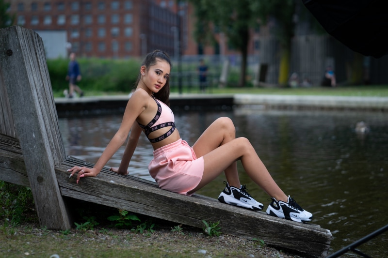 Brunette girl in Nike athletic wear sitting by water