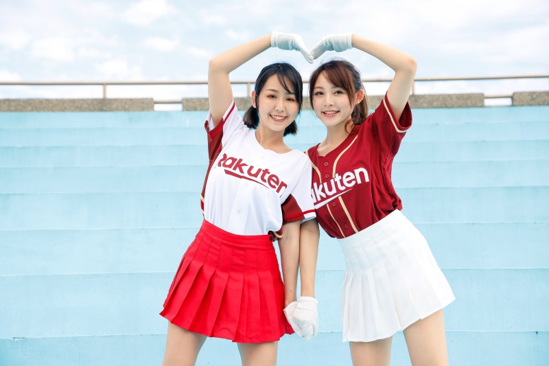 Two smiling Asian women in Rakuten baseball uniforms making a heart shape