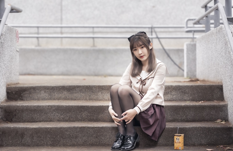 Asian girl in school uniform sitting on stairs
