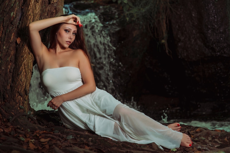 Federica in a white dress by a waterfall