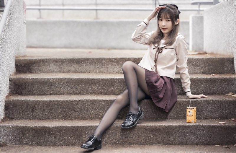 Asian girl in school uniform sitting on stairs