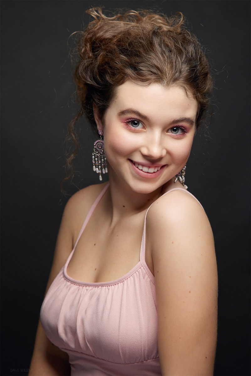 Young woman with curly brown hair and pink top