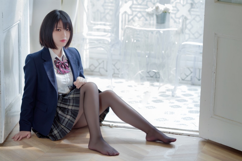 Asian girl in school uniform sitting on floor