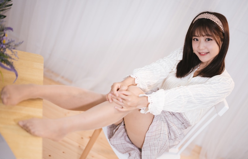 Asian girl in blouse and skirt sitting