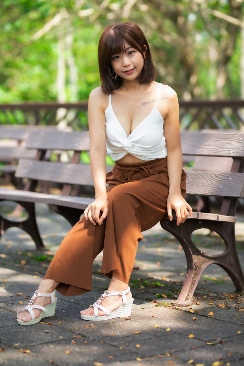 Asian woman sitting on a park bench