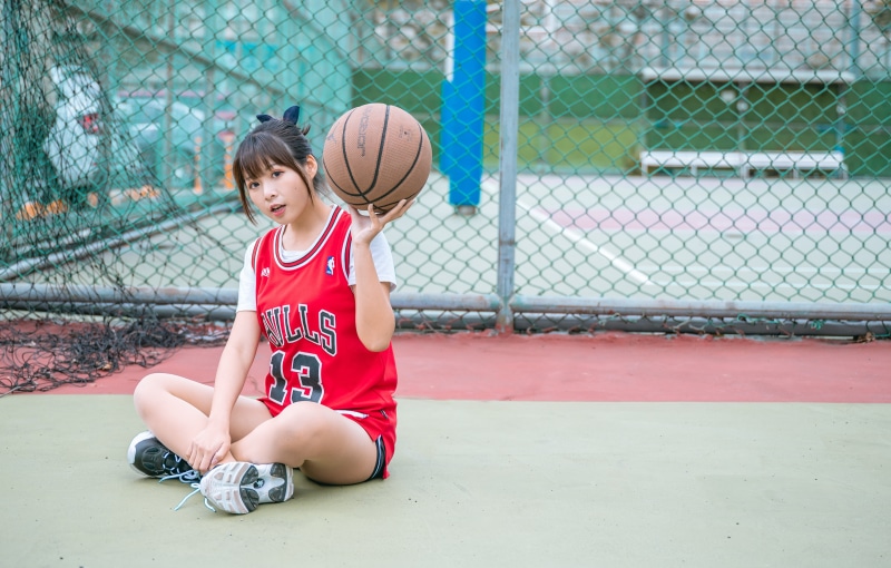 Asian girl in Chicago Bulls uniform holding basketball