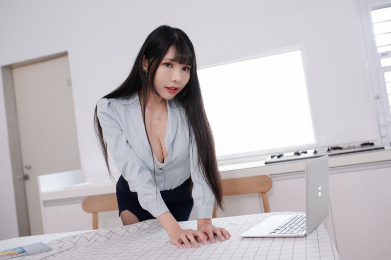 Asian woman in blouse and skirt with laptop