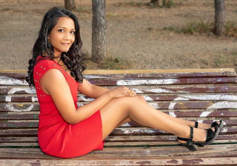 Woman in red dress sitting on a park bench