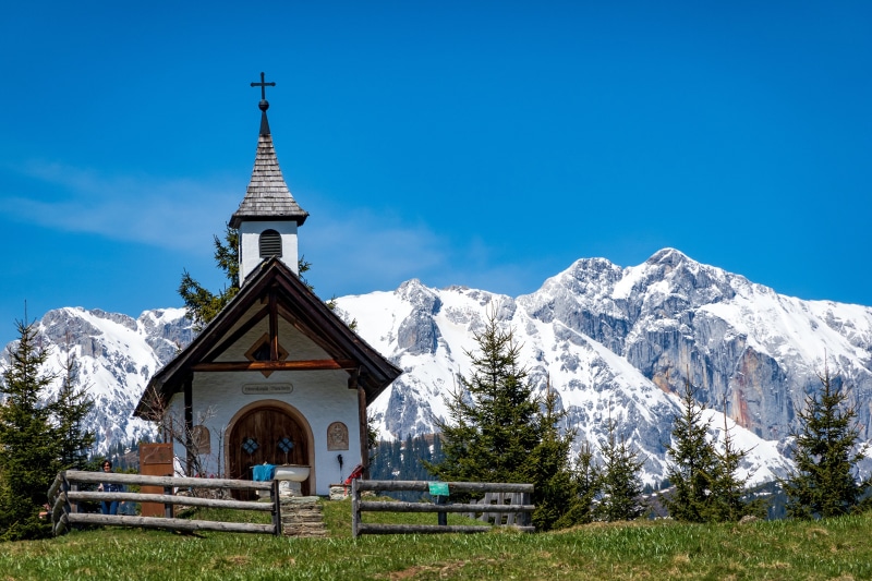 Chapel in Goldegg, Austria with snowy Alps mountains