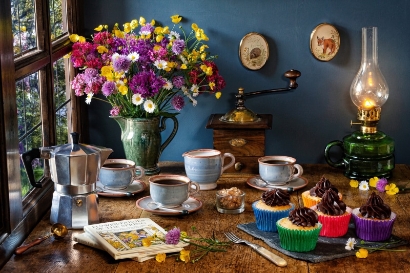 Still-life with coffee, cupcakes, and flowers