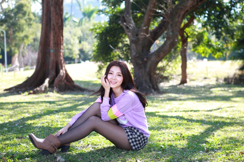 Asian girl sitting on grass in a park