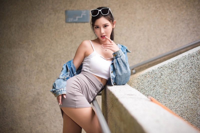 Asian woman in denim jacket and skirt posing