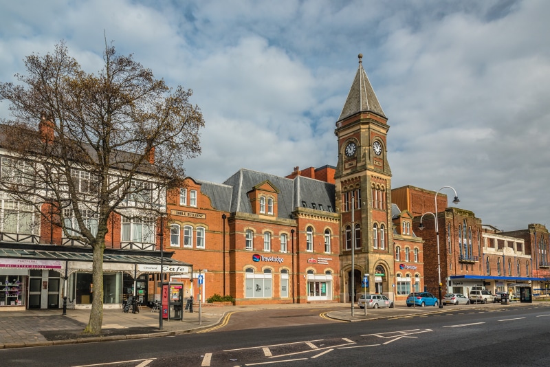 Street view of buildings with a clock tower in Southport, England