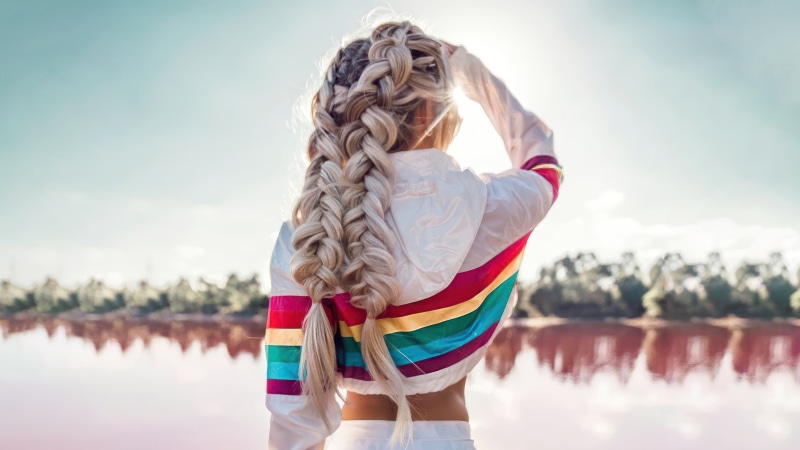 Woman with braided hair by pink lake
