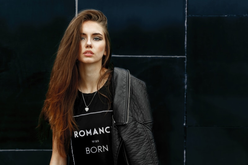 Model wearing a black t-shirt with text and a leather jacket