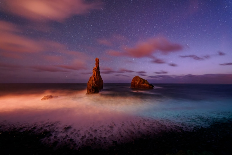 Sea stacks under starry sky at night