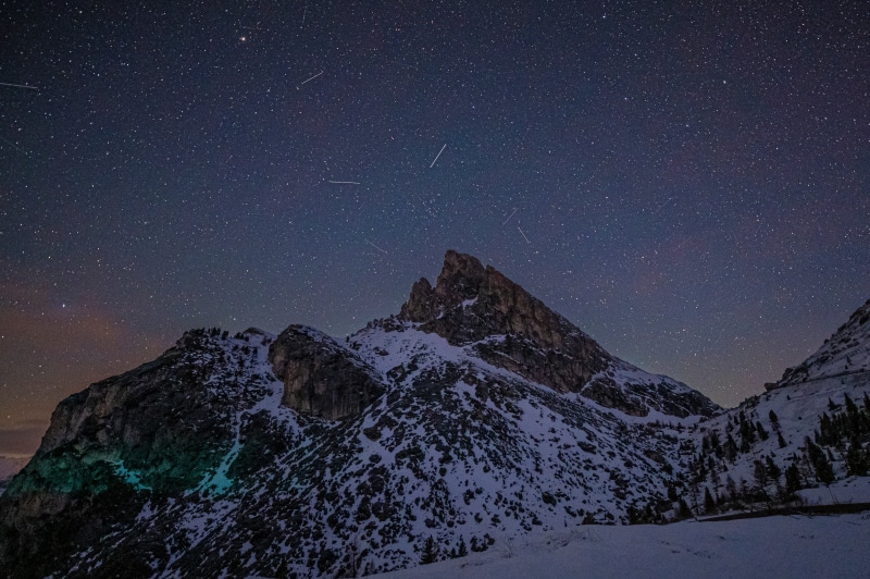 Snowy mountains under a starry night sky