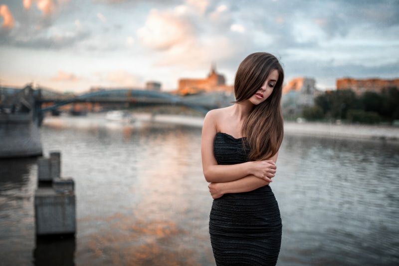 Girl in black dress by the river