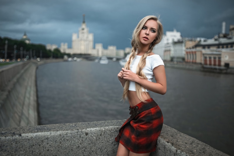 Model with braids in a plaid skirt by the river