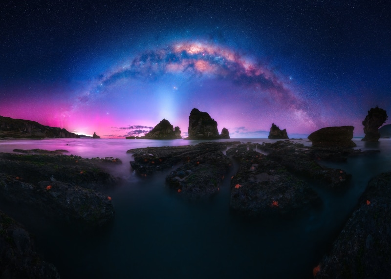 Milky Way over rocky coast with starfish