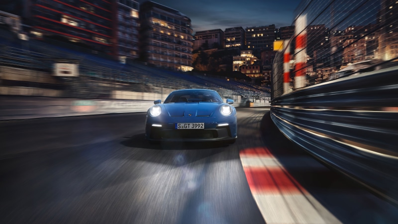 Blue Porsche 911 GT3 on a race track at night