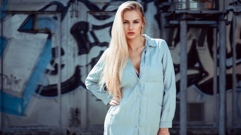 Blonde model in denim shirt against graffiti wall