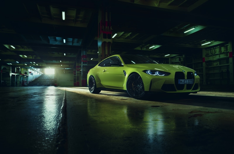 Yellow BMW M4 Coupe in a dimly lit garage