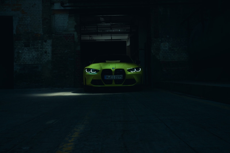 Yellow BMW M4 parked in a dark garage