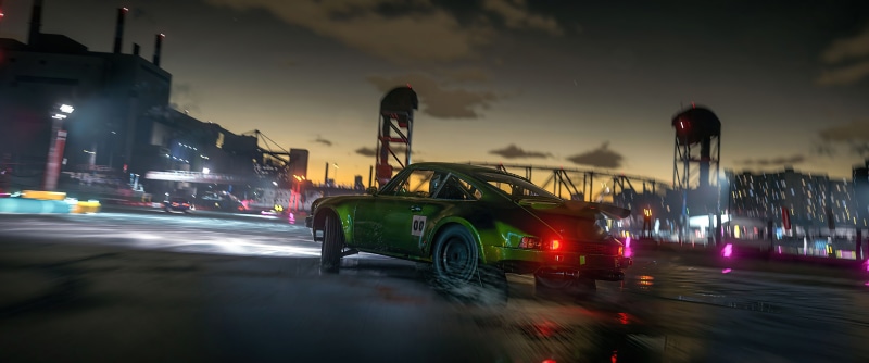 Green Porsche 911 racing in a city at dusk