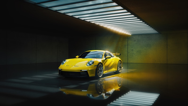 Yellow Porsche 911 GT3 RS in a dark garage