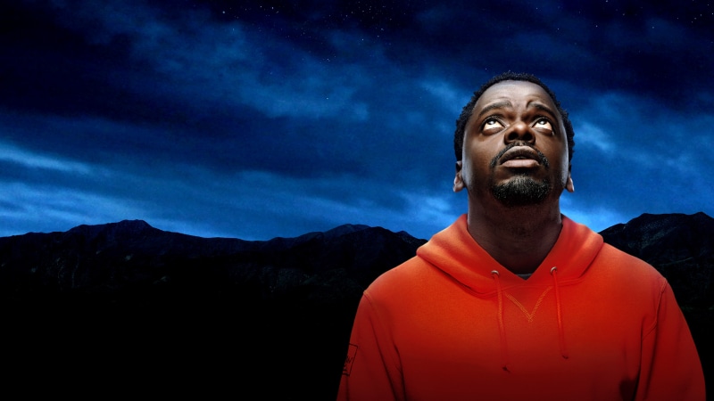 Man in orange hoodie looking at the night sky