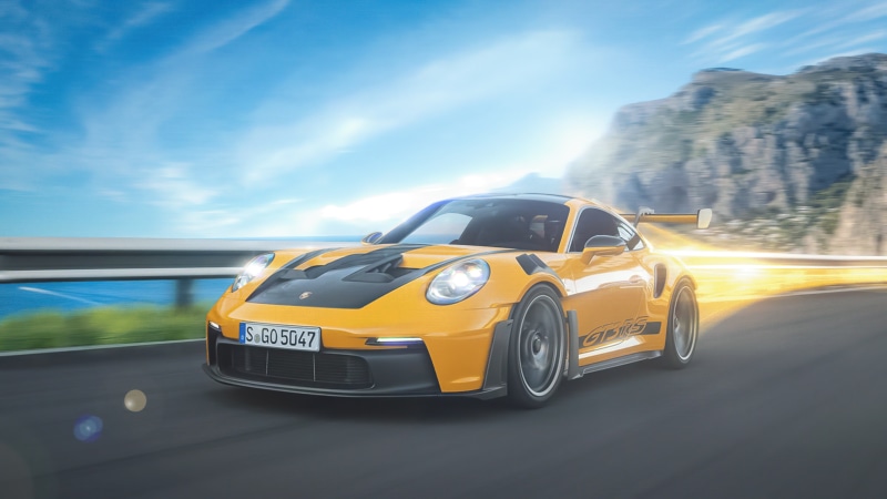 Yellow Porsche 911 GT3 RS driving on a coastal road