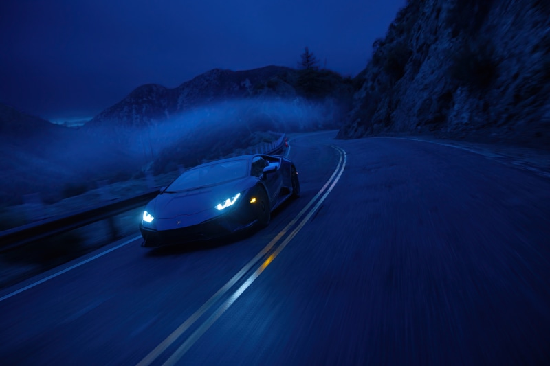 Lamborghini Aventador driving on a mountain road at night