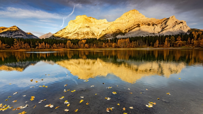 Mountains reflected in a lake with autumn leaves