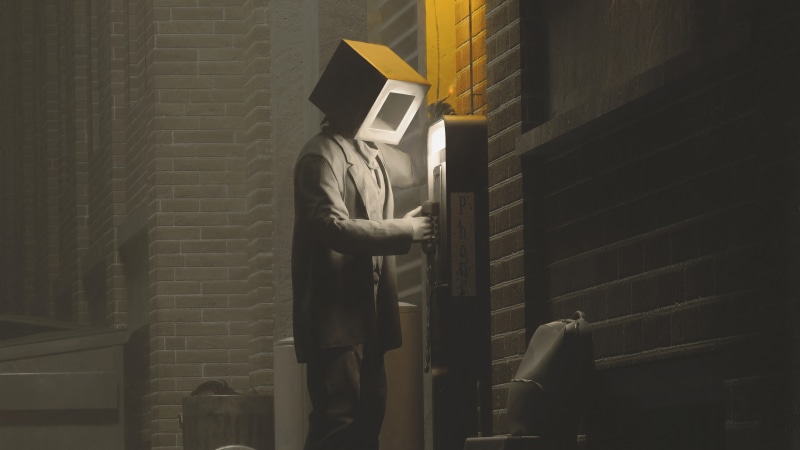 Man with box head using payphone