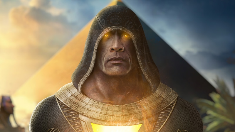 Black Adam with glowing eyes in front of a pyramid
