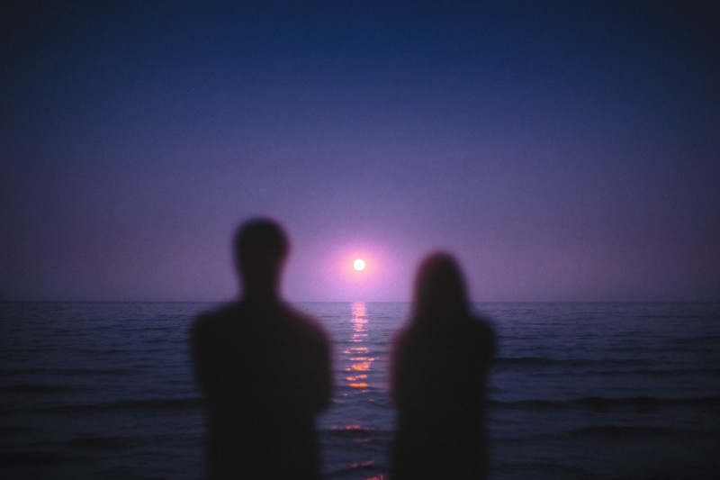 Couple watching the sunset over the ocean