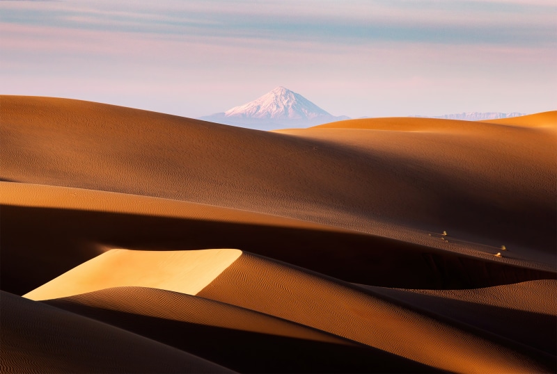 Desert dunes with snow-capped mountain in background