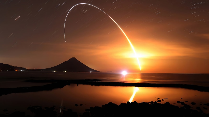 Rocket launch over the ocean at night