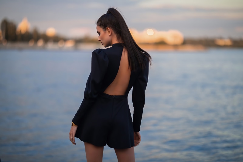 Woman in black dress by the water