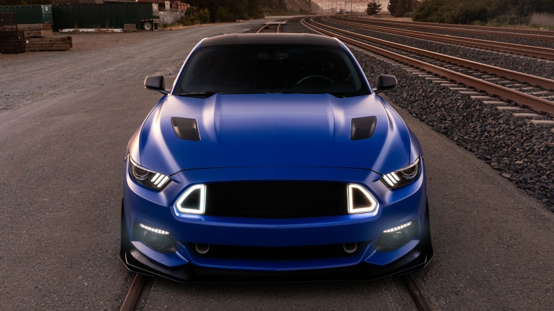 Blue Ford Mustang on Railroad Tracks
