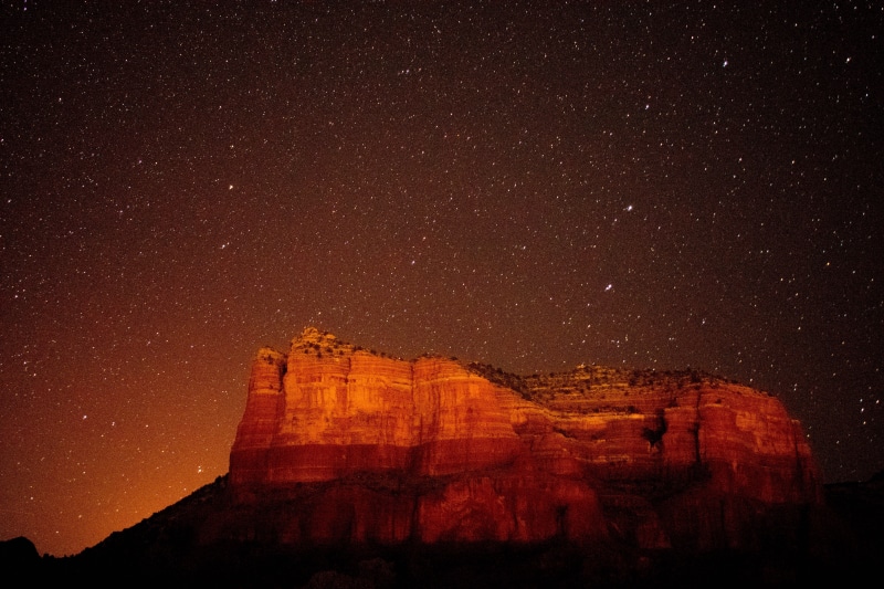 Red rock formations under a starry night sky