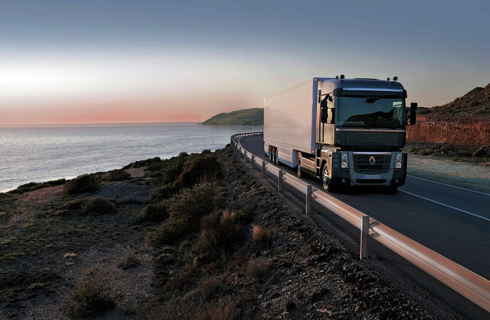 Renault truck on a scenic coastal road at sunset