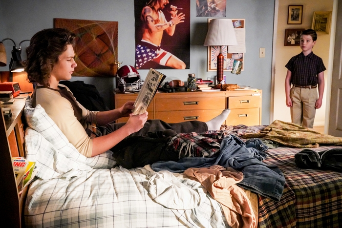 Young Sheldon watches George Cooper Jr. reading in bedroom