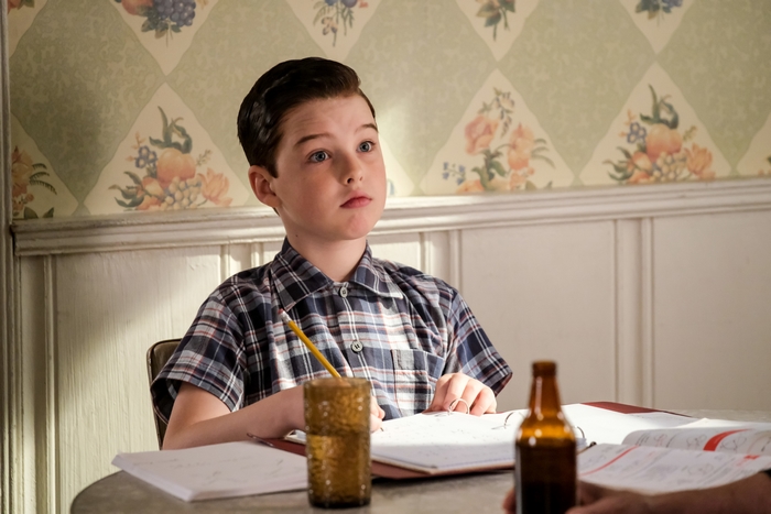Young Sheldon Cooper studying at a table